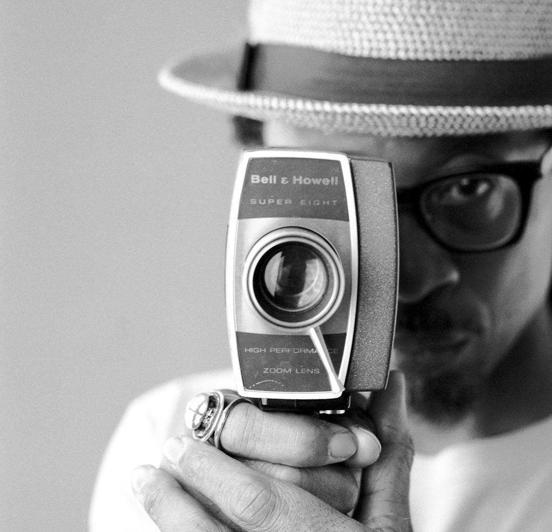 A man holding an old camera in front of his face.