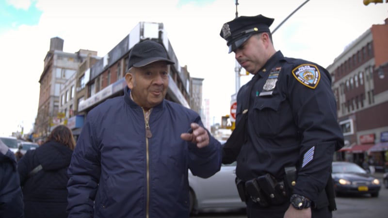 A police officer talking to a man on the street.