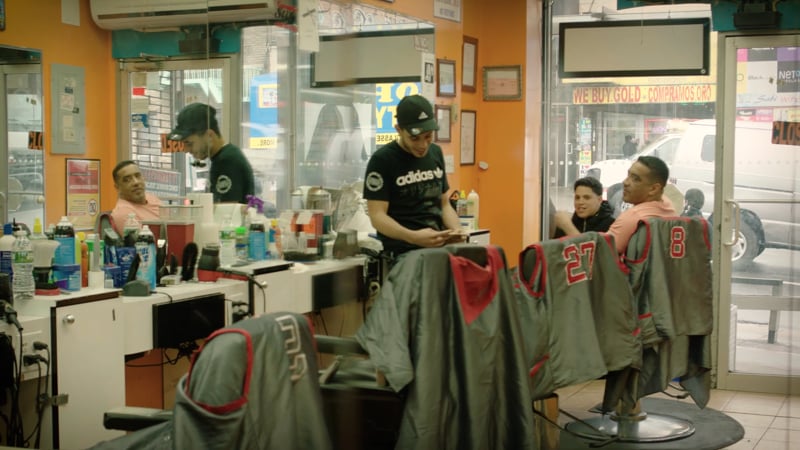 A barber shop with several men working on their uniforms.