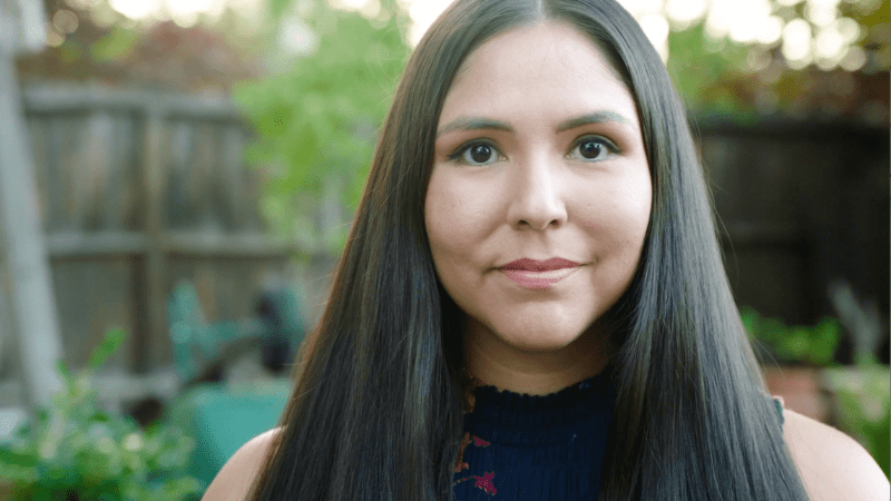 A woman with long black hair and green eyes.