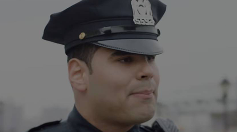 A police officer in uniform is looking at the camera.